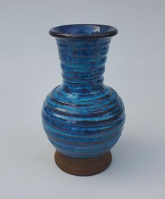 a blue vase sitting on top of a wooden stand