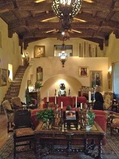 a large living room filled with furniture and a chandelier hanging from the ceiling