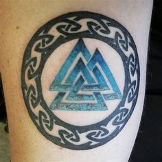 a tattoo on the leg of a person with a blue and black triangle in it