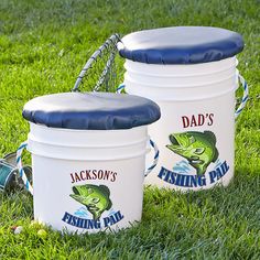 three buckets sitting in the grass on top of a field