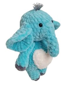 an elephant stuffed animal sitting on top of a white surface with it's trunk in the air