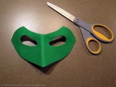 a pair of scissors sitting next to a green mask