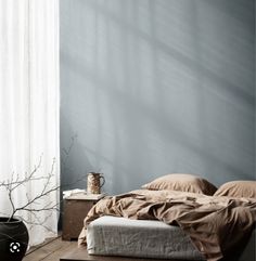 a bed sitting on top of a wooden floor next to a window