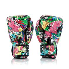 a pair of colorful boxing gloves sitting on top of a white surface with graffiti all over it