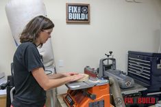 a woman is working on a piece of wood