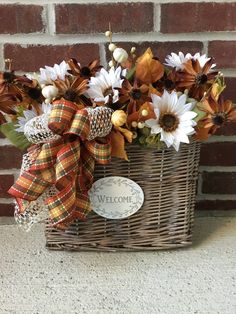 a basket filled with flowers sitting next to a brick wall