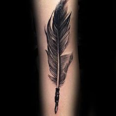 a black and white tattoo with a feather on the arm, next to an ink pen