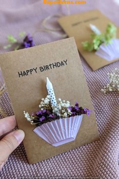 someone is holding a birthday card with flowers in it