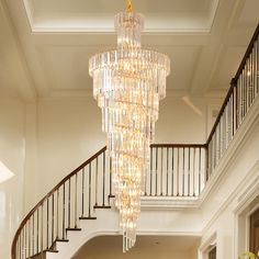 a large chandelier hanging from the ceiling in a living room next to stairs