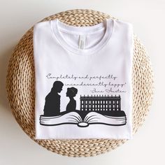 a t - shirt with an image of a man and woman reading a book