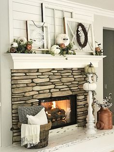 the fireplace is decorated with white pumpkins and greenery