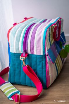 a multicolored striped bag sitting on top of a wooden floor