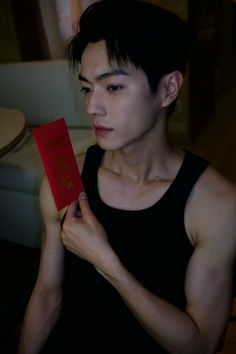 a man holding up a red book with writing on it