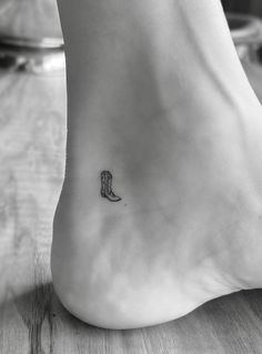 a foot with a small boot tattoo on it