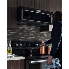 a woman is standing in front of an oven