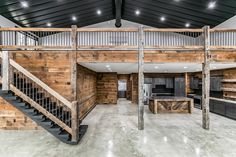 an open floor plan with stairs and wooden walls