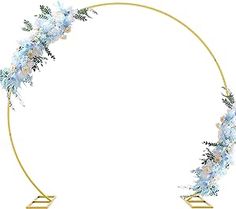 a circular gold frame with blue flowers and greenery on the edges, in front of a white background