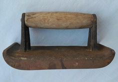 an old iron with a wooden handle on a white background, it looks like something from the 1800s or early 20th century