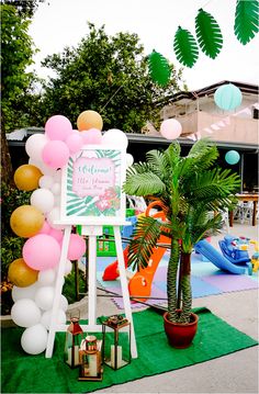 an outdoor party with palm trees and balloons