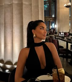 a woman in a black dress sitting at a table