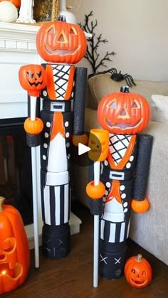 two nutcrackers with jack - o'- lantern faces on their heads