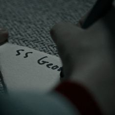 someone is writing on a piece of paper with the word sg gear written in it