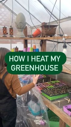 a woman in a greenhouse holding up a sign that says how i heat my greenhouse