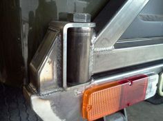 the back end of a vehicle with its door open and an orange handle on it