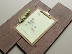 a piece of wood with a clipboard attached to it and a plant on top