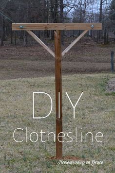 a diy clothesline in the middle of a field with trees and grass behind it