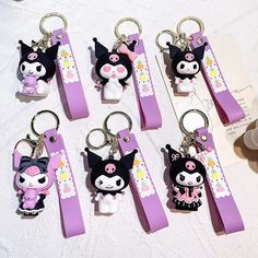 six key chains with cartoon characters on them sitting on a table next to other items