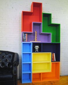 colorful bookshelf with leather chair in front of white brick wall