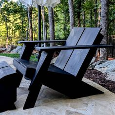 a wooden chair sitting on top of a stone floor next to a tree filled forest