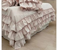 the bed is made with ruffled sheets and pillows