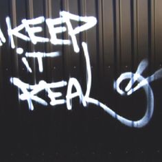 graffiti written on the side of a metal container that says keep it real with white spray paint