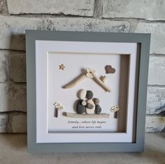 a white frame with some rocks in the shape of a house and stars on it