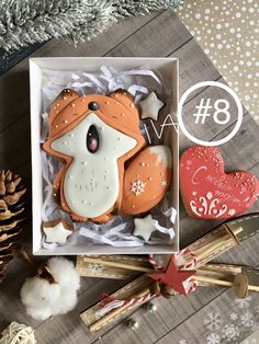 a box with some cookies in it on top of a wooden table next to christmas decorations