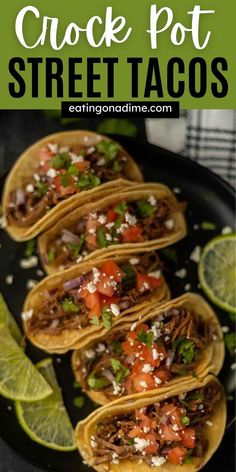 several tacos on a plate with limes and cilantro in the background