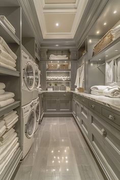 this is a very large laundry room with lots of white linens in the washer and dryer