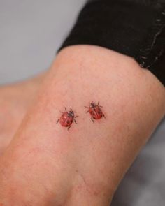 two ladybugs sitting on the back of a woman's leg