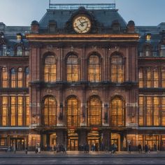 a large building with a clock on the top of it's face at night