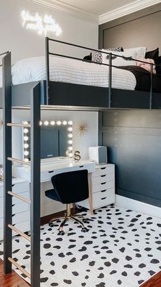 a bedroom with a loft bed, desk and chair next to a white dresser in the corner