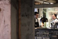 two people standing at a counter in a restaurant