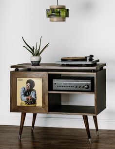 an old record player is sitting on top of a wooden cabinet with a vinyl album