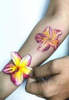 two people with matching tattoos holding each other's hands and one has a flower on it