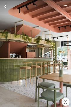 the interior of a restaurant with tables, chairs and plants hanging from the rafters