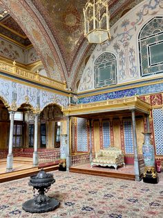 an ornately decorated room with chandelier and couches in the middle of it