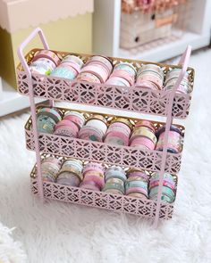 two tiered trays filled with different types of macaroons on a white rug