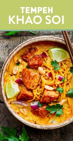 a bowl filled with shrimp and noodles next to chopsticks on the side, along with cilantro