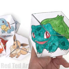 someone is holding up some origami with pokemons on them and the other one has